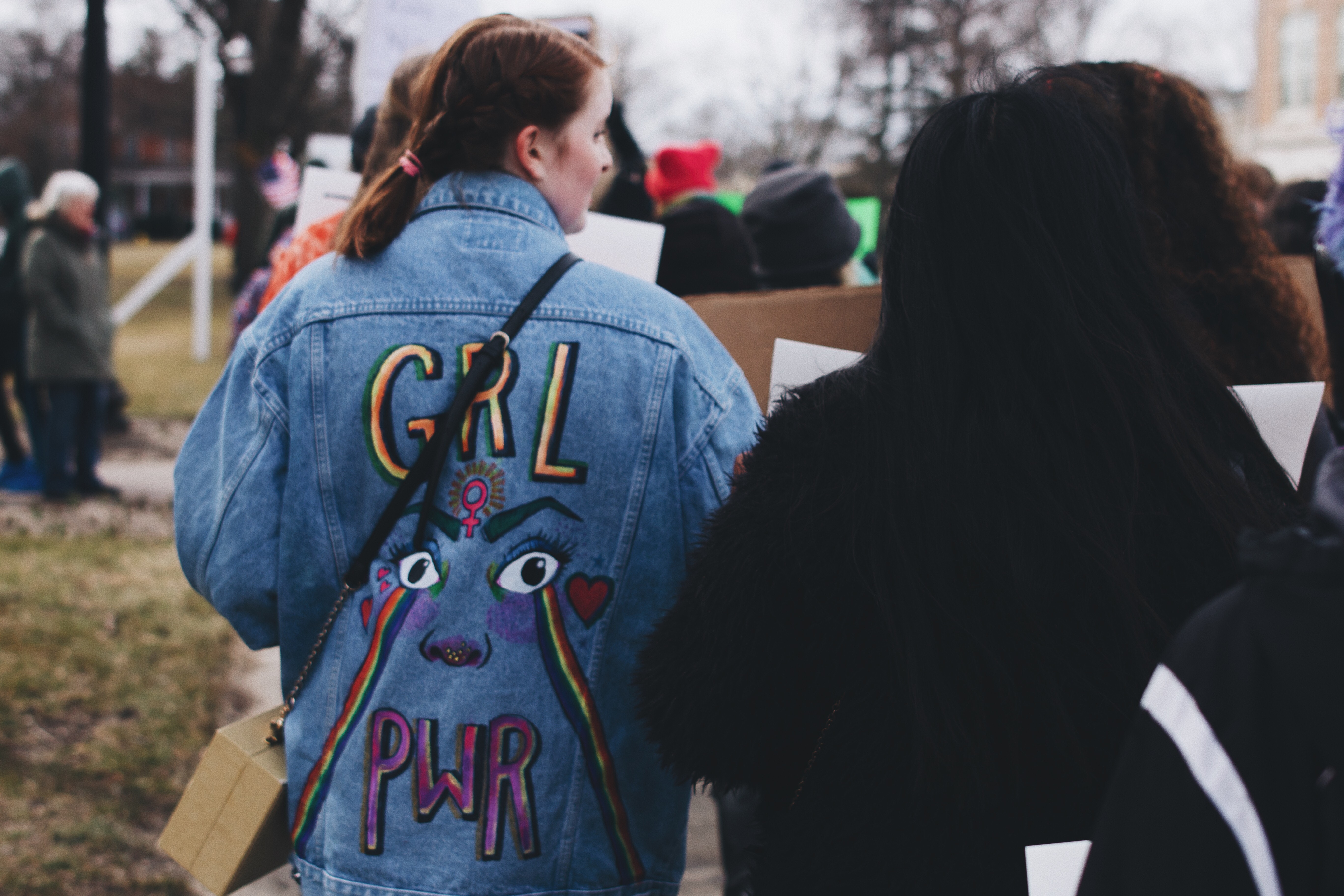 Women marching wearing a "girl power" denim jacket Women marching wearing a "girl power" denim jacket