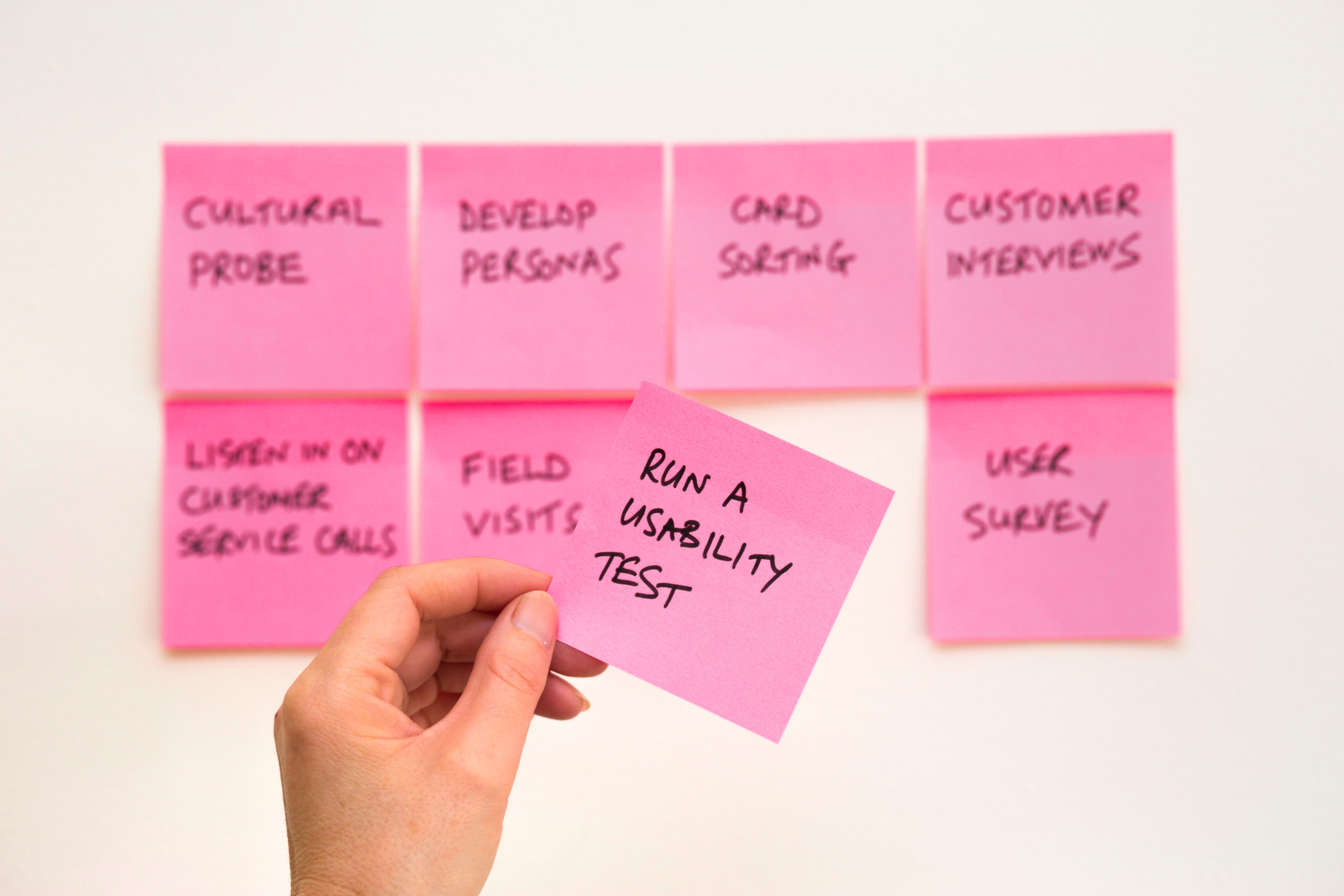 Person holding a pink sticky note.