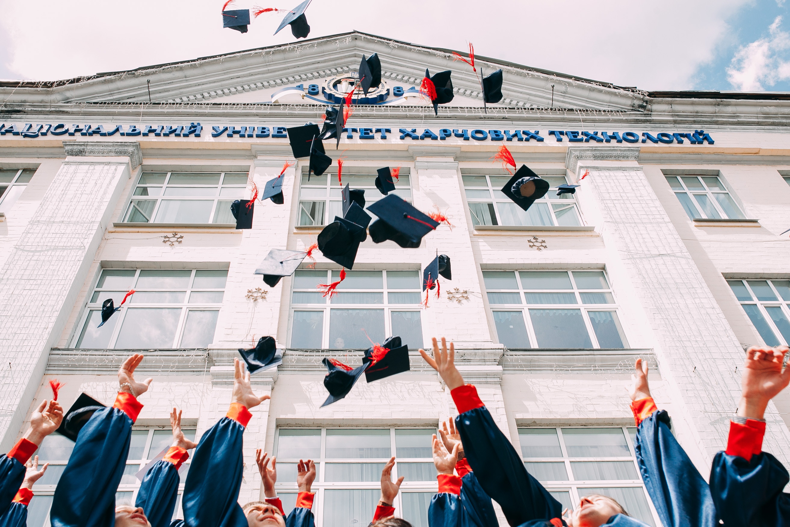 Graduation Hands throwing graduation caps in the air.